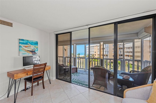 home office featuring expansive windows and light tile patterned floors