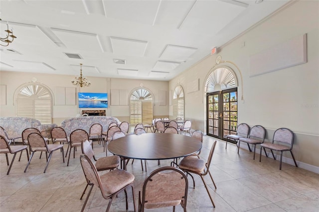 tiled dining room featuring a healthy amount of sunlight, a chandelier, and french doors