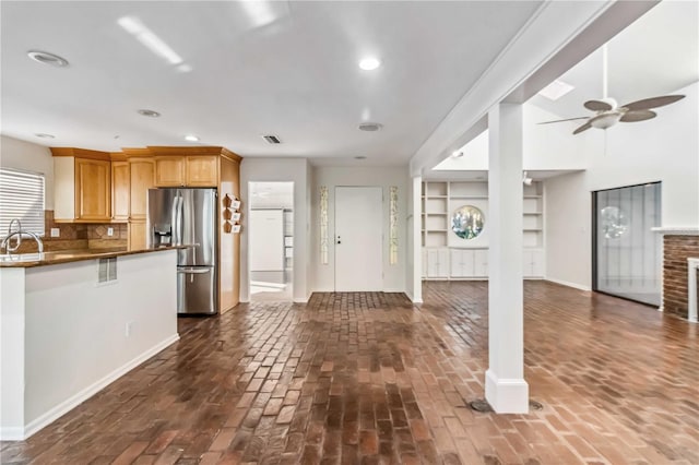 2375 Riverwood Pines Dr, Sarasota, FL 34231 - kitchen featuring sink, stainless steel fridge, ceiling fan, backsplash, and a fireplace