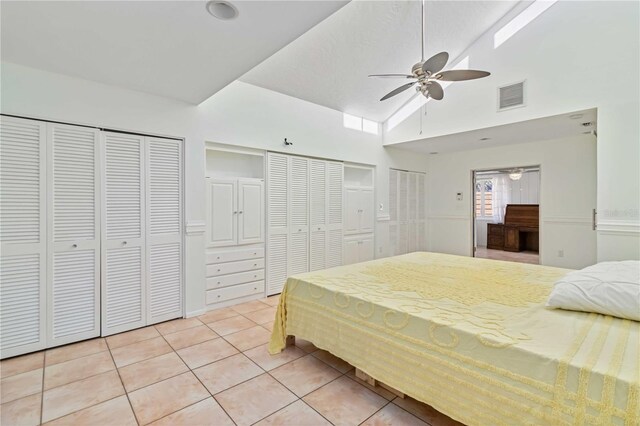 2375 Riverwood Pines Dr, Sarasota, FL 34231 - bedroom with light tile patterned flooring, ceiling fan, high vaulted ceiling, and two closets