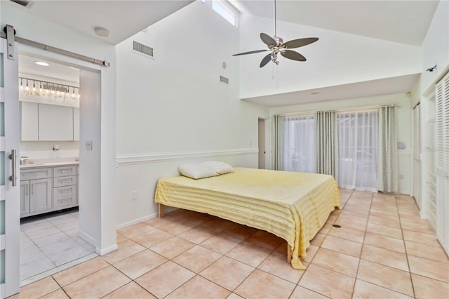 2375 Riverwood Pines Dr, Sarasota, FL 34231 - bedroom featuring light tile patterned floors, sink, a barn door, and ensuite bathroom