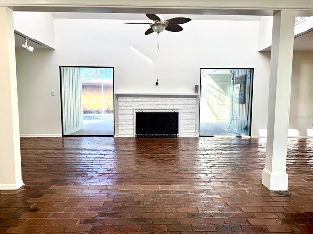 2375 Riverwood Pines Dr, Sarasota, FL 34231 - unfurnished living room featuring a towering ceiling, a fireplace, and ceiling fan