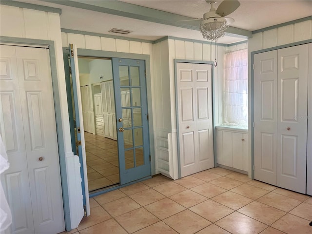 2375 Riverwood Pines Dr, Sarasota, FL 34231 - unfurnished bedroom featuring light tile patterned floors, beam ceiling, multiple closets, and wood walls