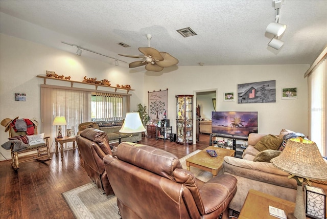 living room with ceiling fan, lofted ceiling, dark hardwood / wood-style floors, and a textured ceiling