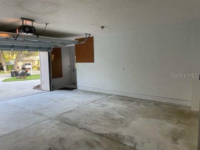 garage with baseboards and a garage door opener