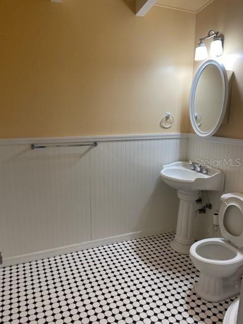 bathroom featuring toilet and wainscoting