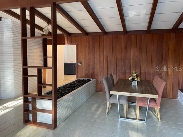 interior space featuring lofted ceiling with beams and wood walls