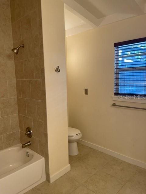 bathroom featuring toilet, shower / bath combination, and baseboards