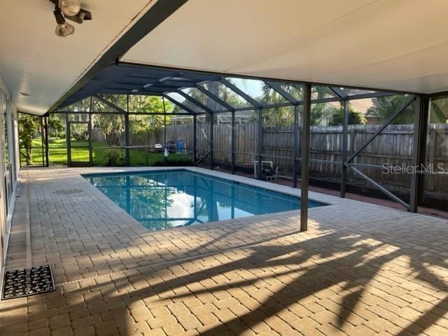 view of swimming pool with a fenced in pool, a lanai, a fenced backyard, and a patio