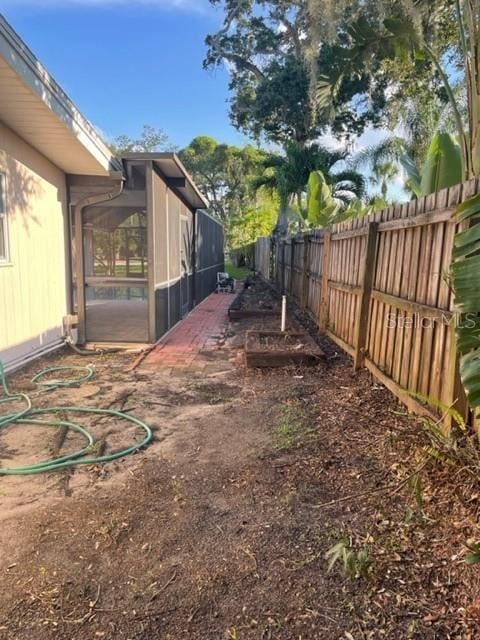 view of yard featuring a sunroom and a fenced backyard