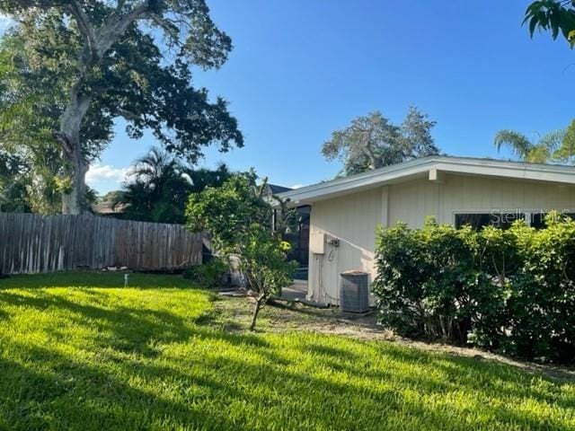 view of yard with central AC unit and fence