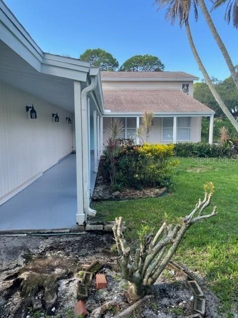 view of side of home with a yard