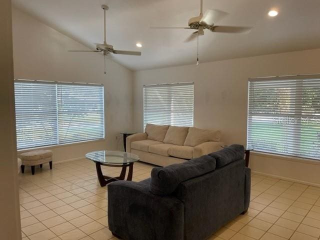 living area featuring a healthy amount of sunlight, light tile patterned floors, ceiling fan, and vaulted ceiling