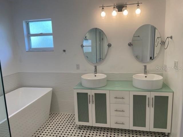 full bath with a soaking tub, a sink, and double vanity