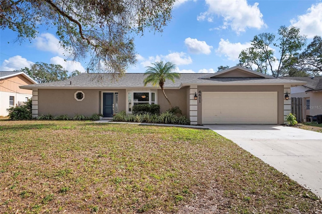 ranch-style home with a garage and a front yard