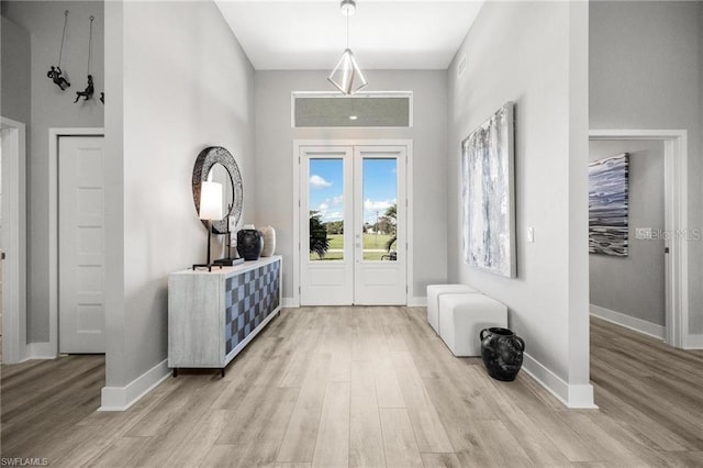 entrance foyer with light hardwood / wood-style floors and french doors