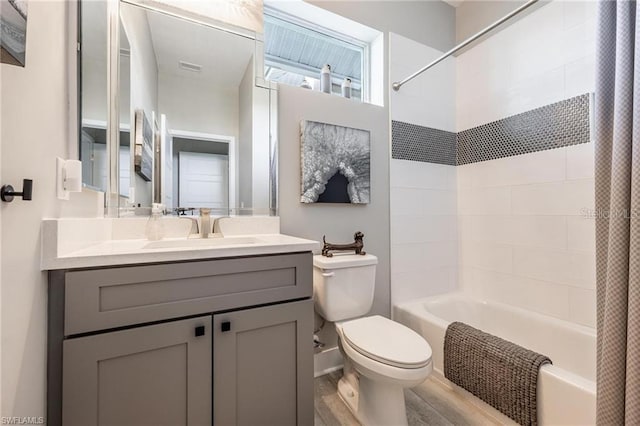 full bathroom featuring hardwood / wood-style flooring, vanity, shower / bathtub combination with curtain, and toilet