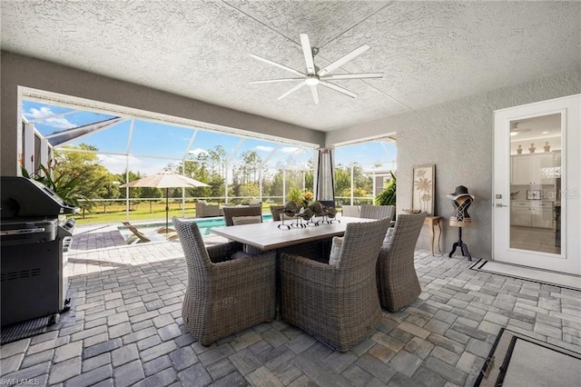 view of patio featuring ceiling fan and glass enclosure