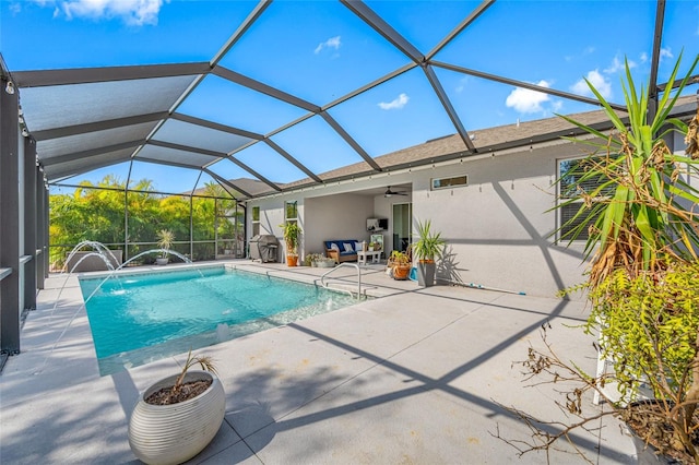 view of swimming pool with a patio, ceiling fan, and glass enclosure