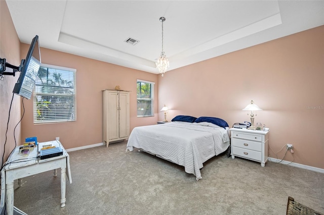 carpeted bedroom featuring a tray ceiling