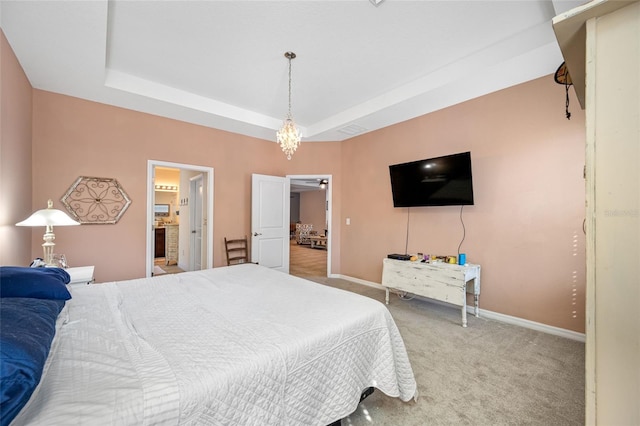 carpeted bedroom with a raised ceiling