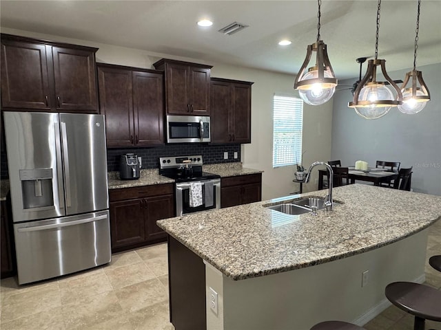 5821 Hevena Ct, Palmetto, FL 34221 - kitchen featuring stainless steel appliances, a sink, tasteful backsplash, light stone counters, and dark brown cabinets