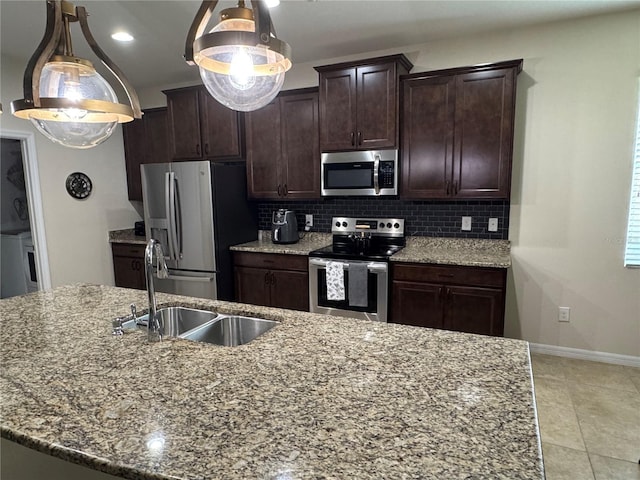 5821 Hevena Ct, Palmetto, FL 34221 - kitchen featuring appliances with stainless steel finishes, decorative backsplash, dark brown cabinetry, a sink, and light stone counters