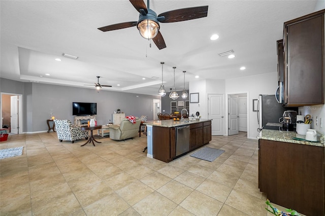 5821 Hevena Ct, Palmetto, FL 34221 - kitchen with a ceiling fan, dishwasher, dark brown cabinets, open floor plan, and an island with sink