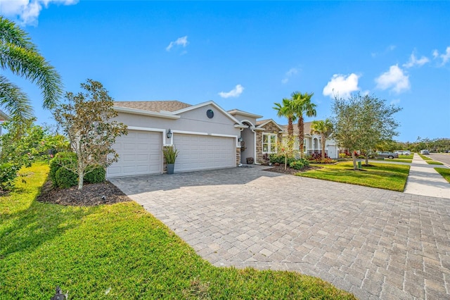 5821 Hevena Ct, Palmetto, FL 34221 - view of front facade with stucco siding, a garage, a front yard, and decorative driveway