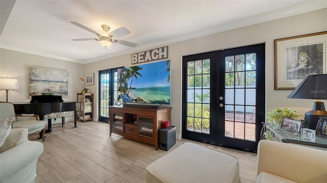 living room featuring crown molding, light hardwood / wood-style floors, ceiling fan, and french doors