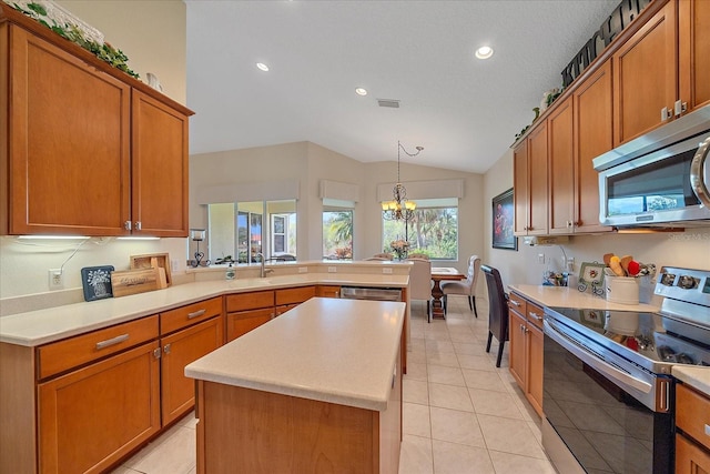 kitchen featuring appliances with stainless steel finishes, a kitchen island, decorative light fixtures, light tile patterned flooring, and kitchen peninsula