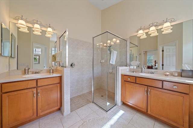 bathroom featuring tile patterned flooring, vanity, and a tile shower