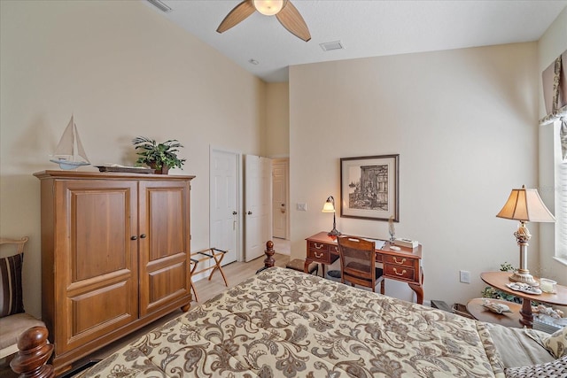 bedroom featuring ceiling fan, a towering ceiling, and light wood-type flooring