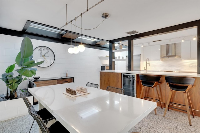 dining space featuring beverage cooler and sink