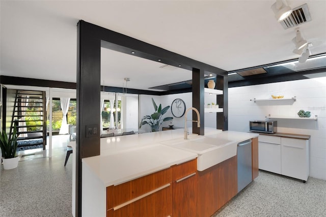 kitchen with pendant lighting, sink, stainless steel appliances, and white cabinets