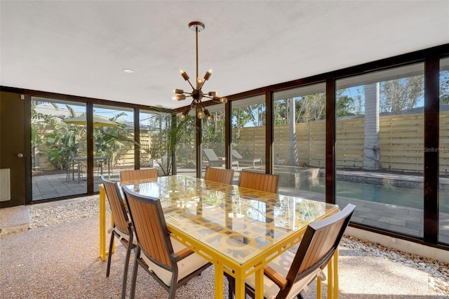 sunroom featuring a notable chandelier and plenty of natural light