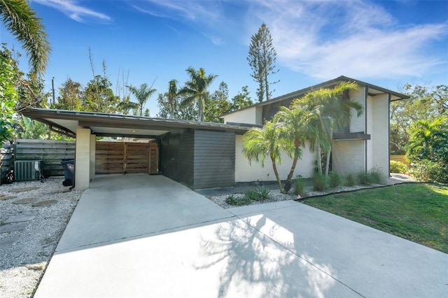 contemporary house with a carport, central AC, and a front yard