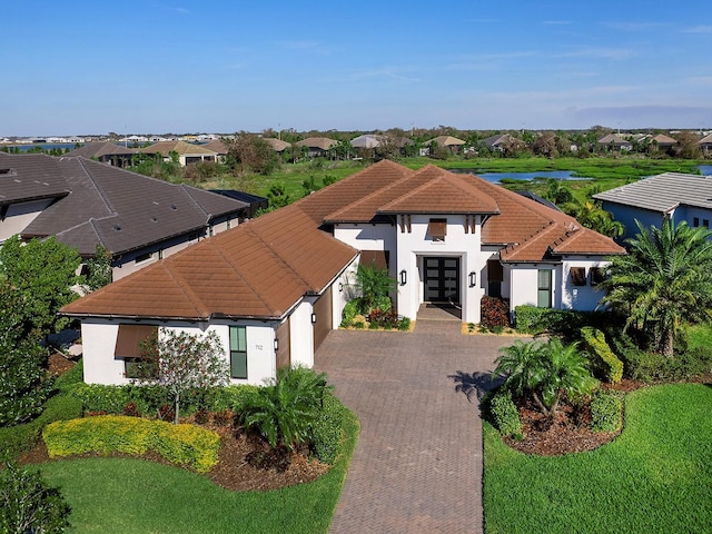 view of front facade featuring stucco siding, a residential view, decorative driveway, and french doors