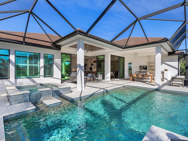 pool featuring a lanai, an in ground hot tub, a ceiling fan, exterior kitchen, and a patio area