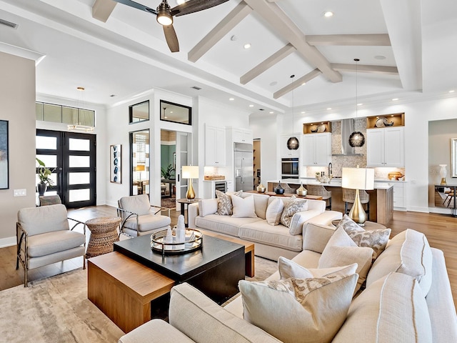 living area with high vaulted ceiling, beam ceiling, baseboards, and light wood finished floors