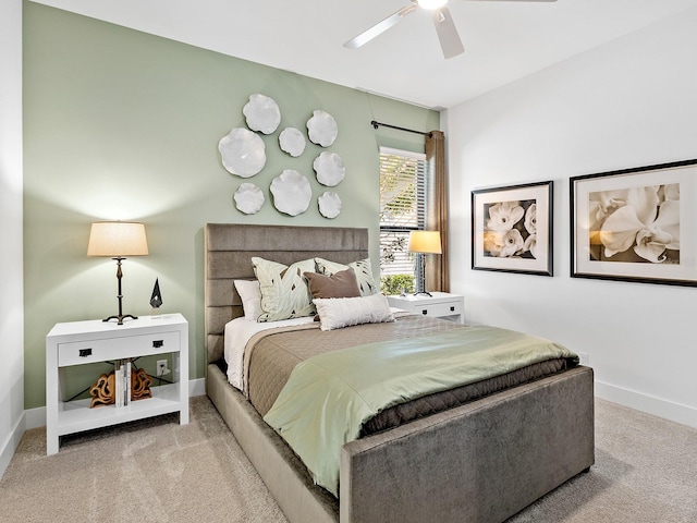 bedroom with light colored carpet, ceiling fan, and baseboards