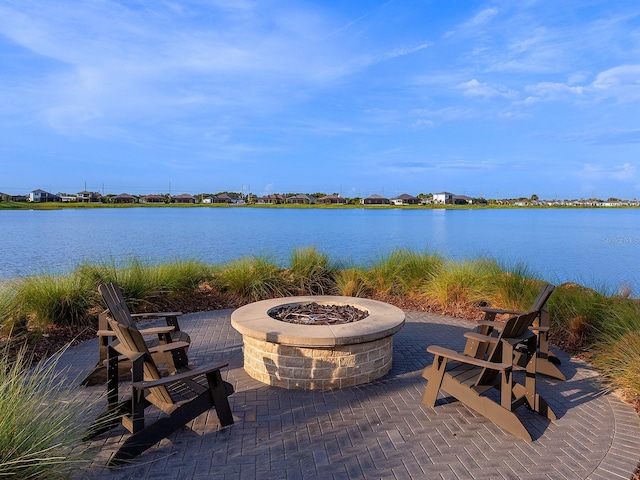 view of patio with a water view and an outdoor fire pit