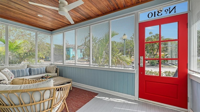 sunroom / solarium with a healthy amount of sunlight, wooden ceiling, and a ceiling fan