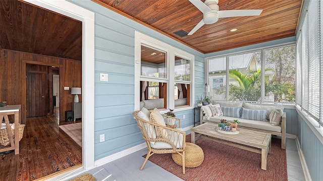 sunroom / solarium with a ceiling fan and wooden ceiling