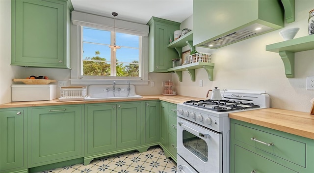 kitchen with light floors, open shelves, butcher block counters, a sink, and white gas range oven