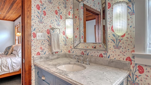 ensuite bathroom with ensuite bathroom, wooden ceiling, vanity, and wallpapered walls