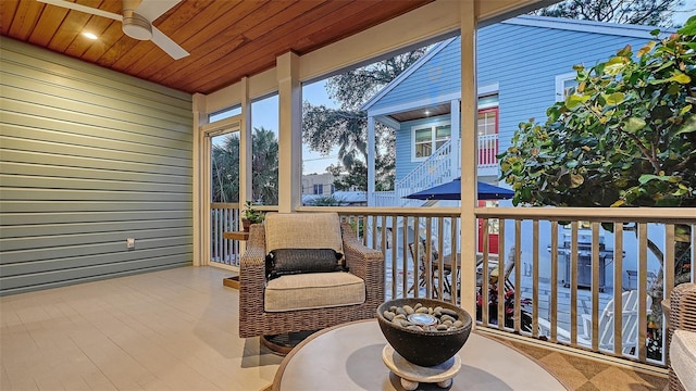 sunroom / solarium with wood ceiling and a ceiling fan