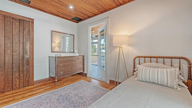 bedroom featuring access to outside, wooden ceiling, and wood finished floors