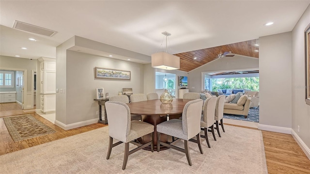 dining space with a wealth of natural light, light hardwood / wood-style flooring, and vaulted ceiling