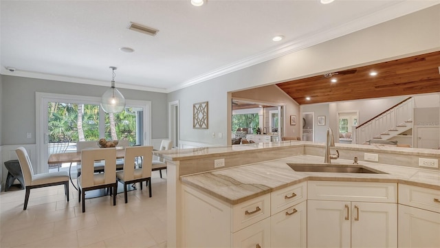 kitchen featuring ornamental molding, pendant lighting, sink, and a wealth of natural light